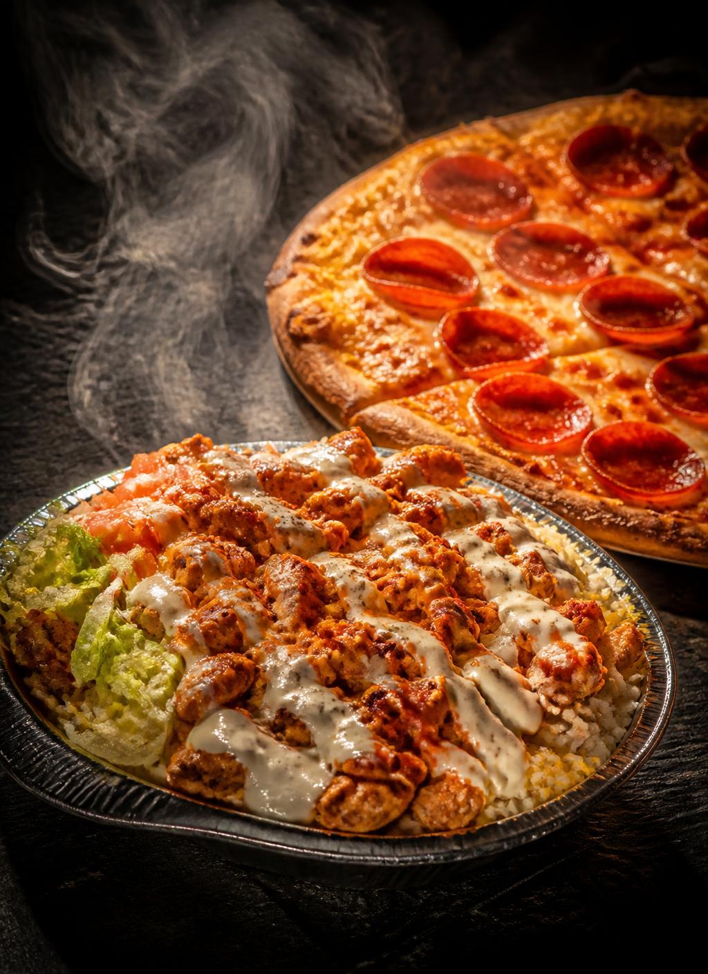Chicken over rice with white sauce beside a fresh pepperoni pizza